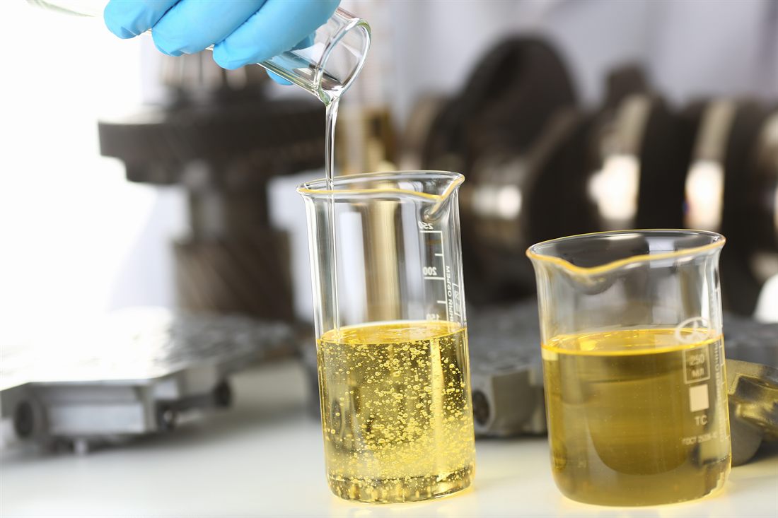 Base oil being poured into laboratory beakers